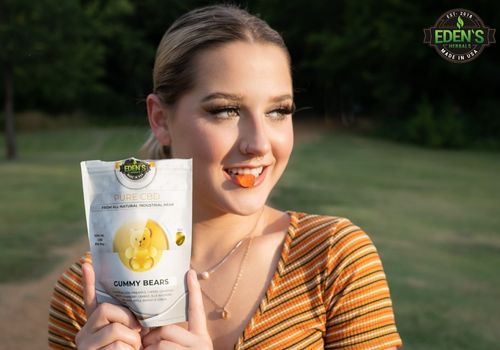 woman holding eden's herbals cbd gummies up to her mouth 